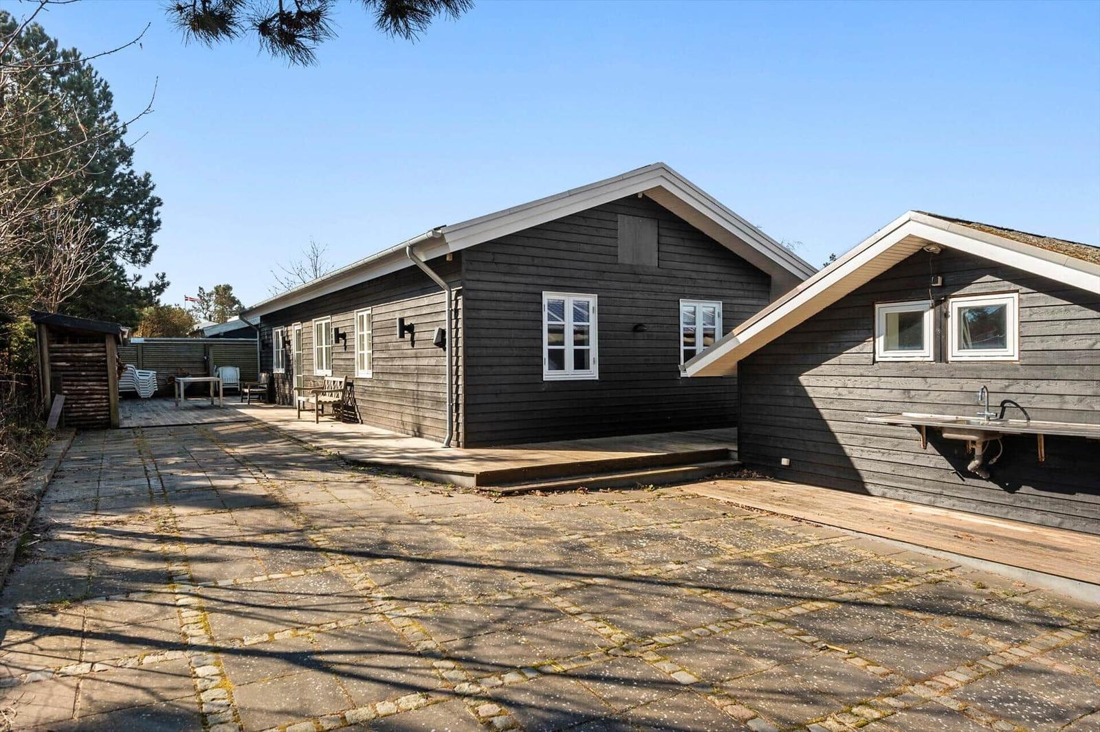 Holzhaus mit Terrasse und Außendusche im Garten