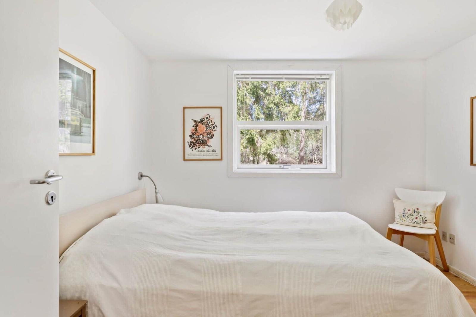 Schlafzimmer mit Bett, Fenster und Stuhl