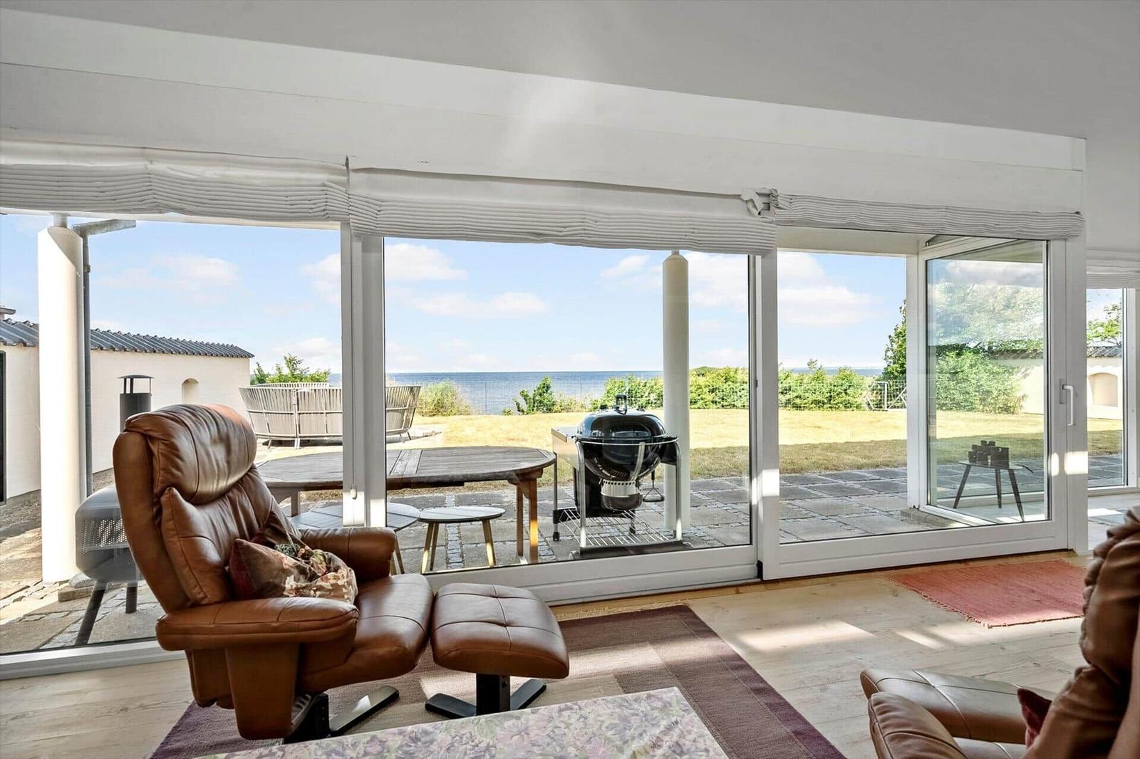 Lounge chair with view of the beach and barbecue area.