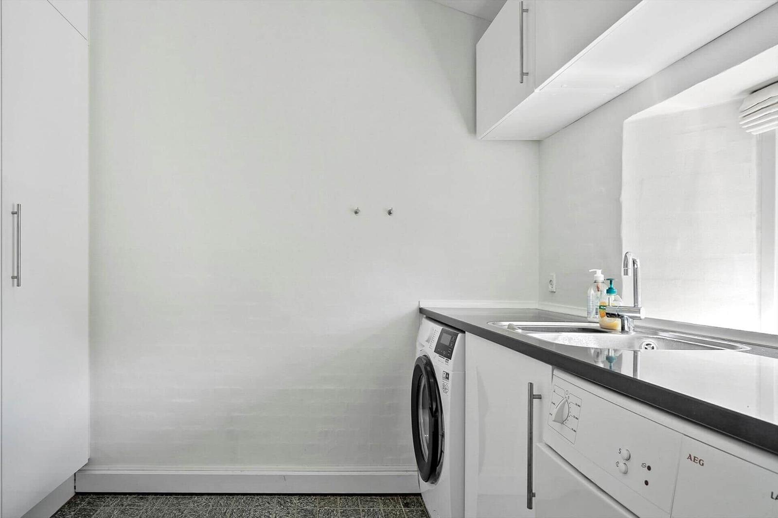 Kitchen with washing machine, dishwasher, and sink.