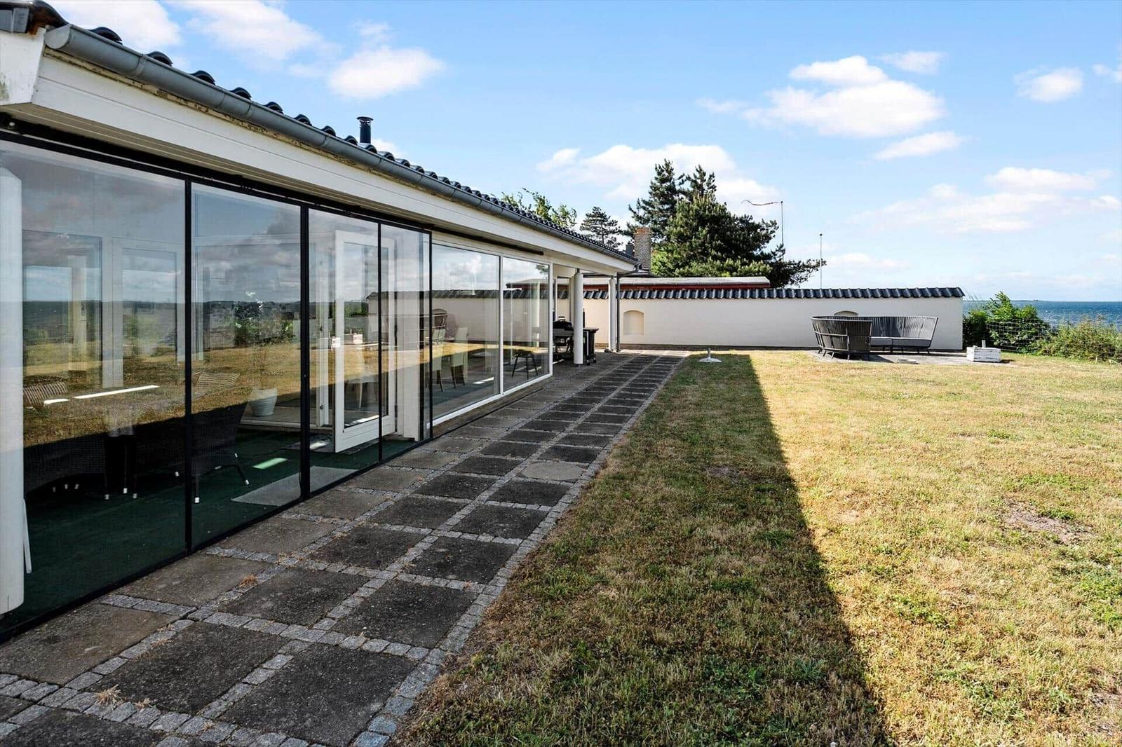 Modern villa with large glass area and garden. View of sea and sky.