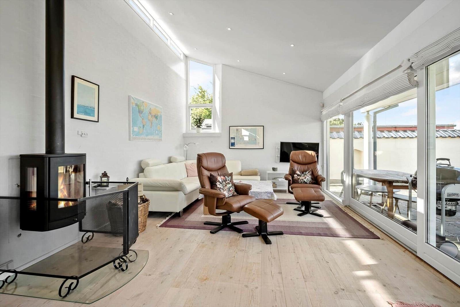 Living room with fireplace, leather chairs, and terrace