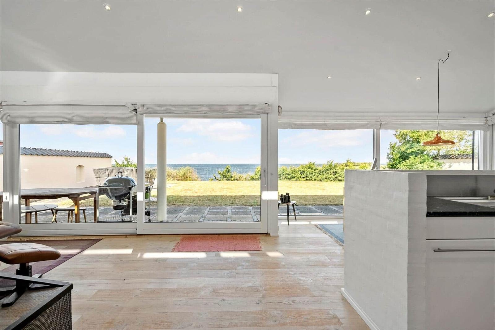 Living area with view of the beach and garden. Terrace with grill and table.