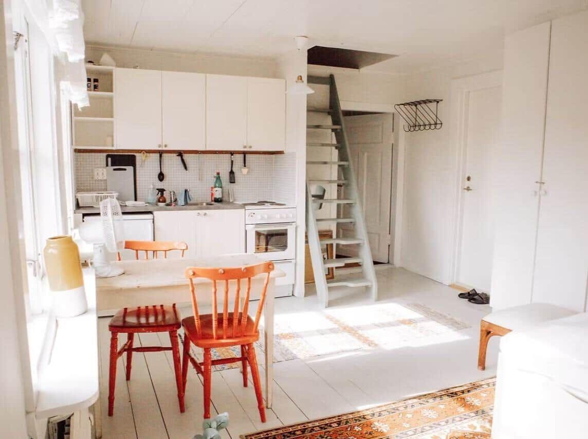 Küche mit Essbereich, Treppe zur oberen Etage und hellem Holzboden.
