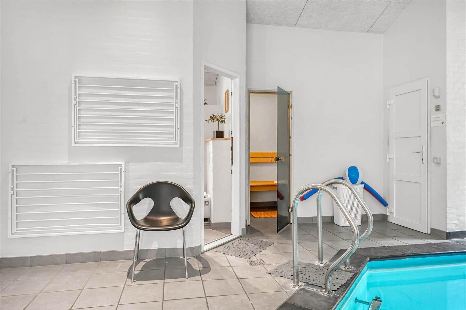 Innenpool mit Dusche, Sauna und Stuhl. Poolbereich mit Aufstiegsleiter.