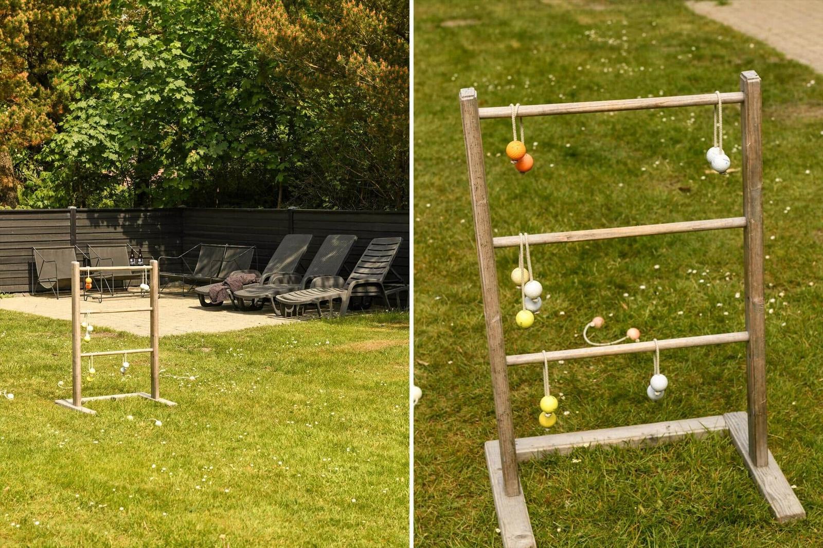 Holzspielgeräte auf Grünfläche, Liegestühle im Hintergrund.