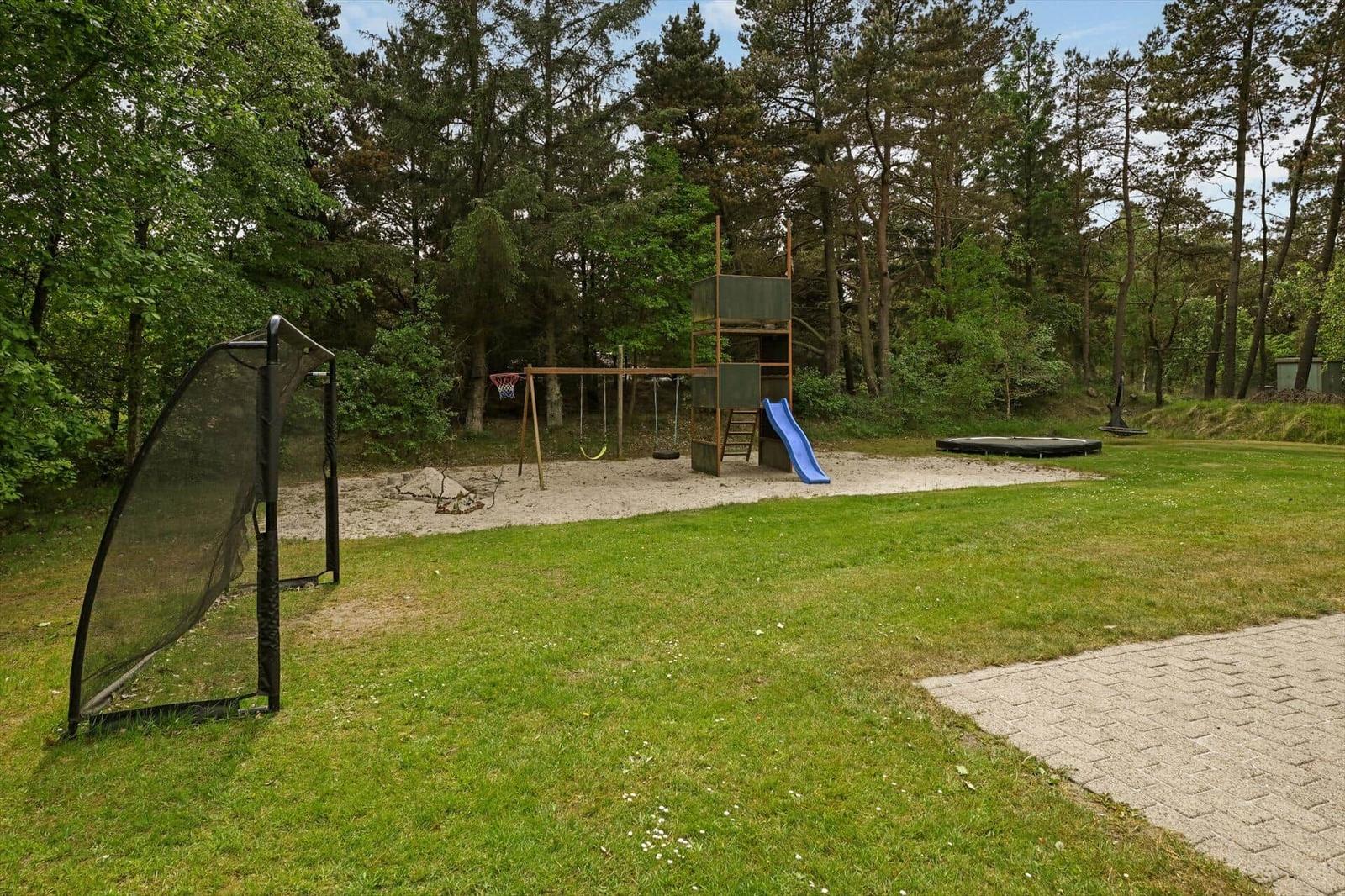 Großer Garten mit Spielplatz, Klettergerüst, Rutsche und Trampolin.