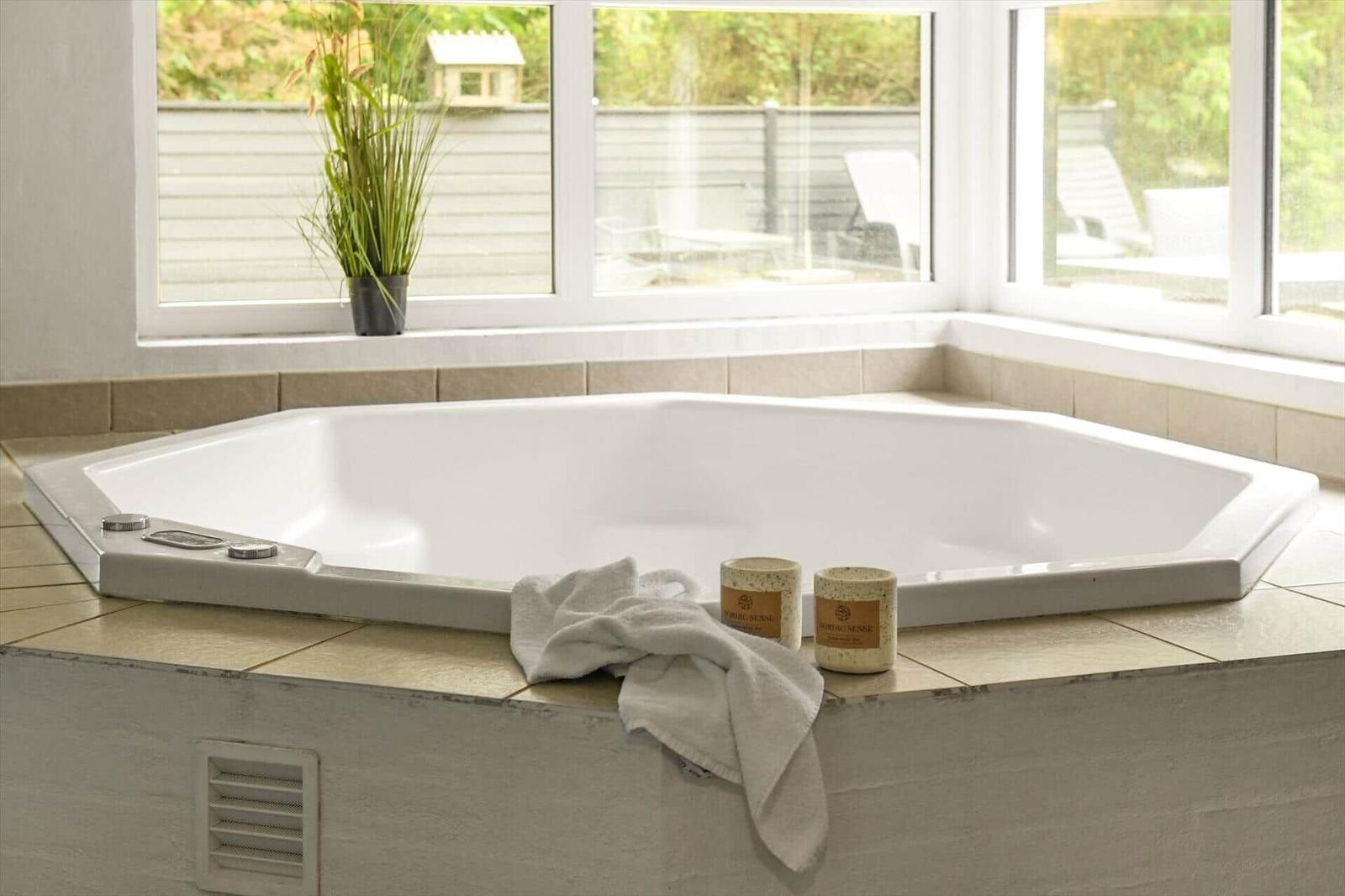 Eine große Whirlpool-Badewanne mit Blick auf den Garten.