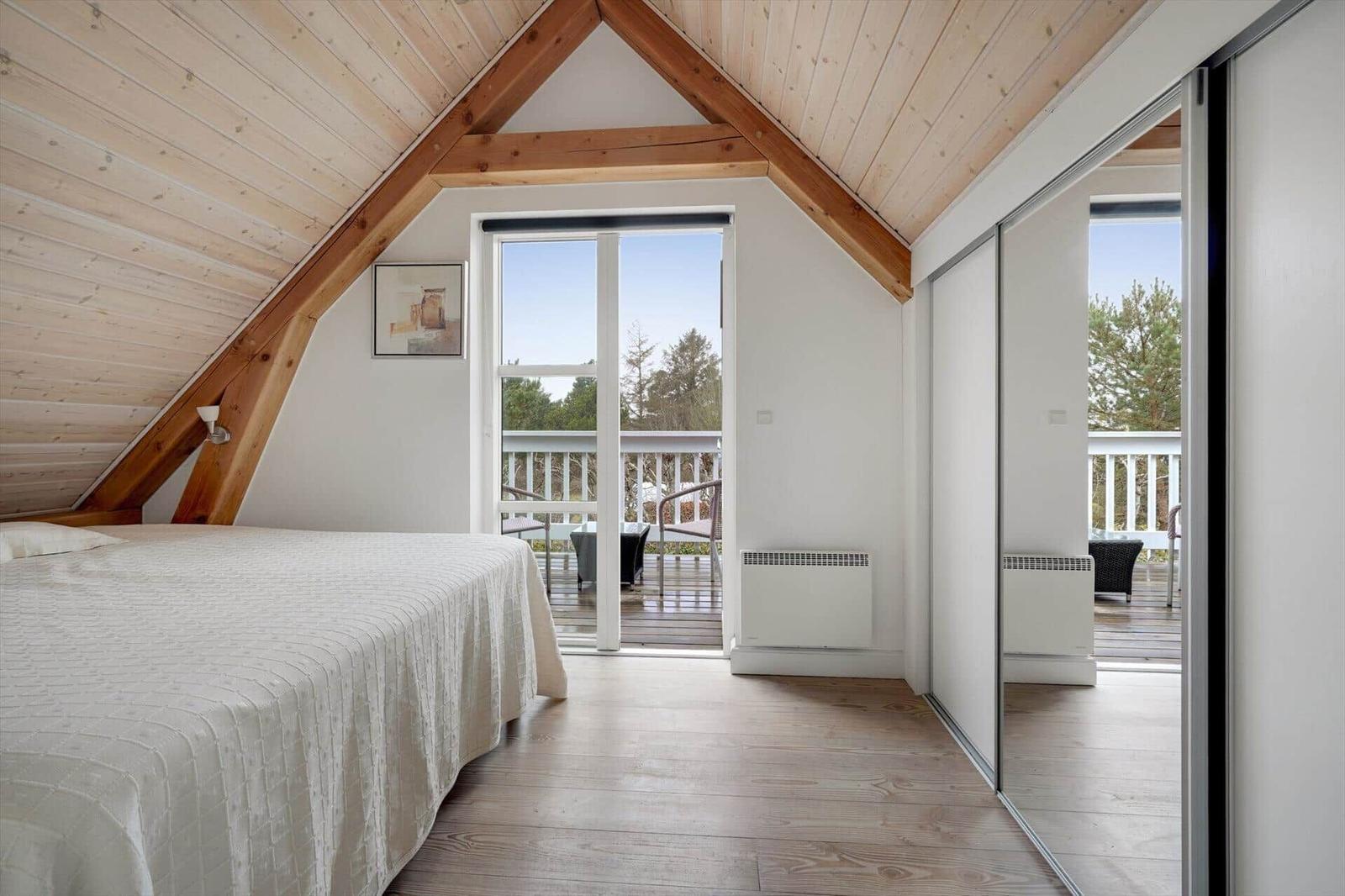 Schlafzimmer mit Dachschrägen, Balkon und Holzboden