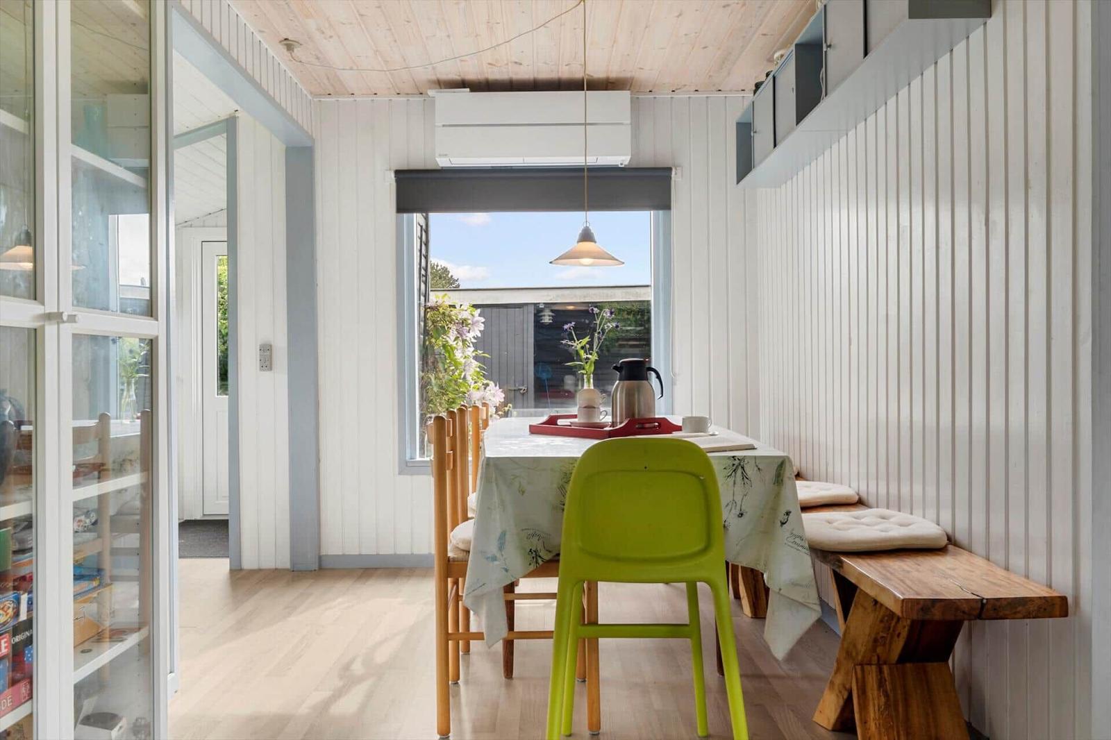 Essbereich mit Tisch, Stühlen und Fenster zum Garten