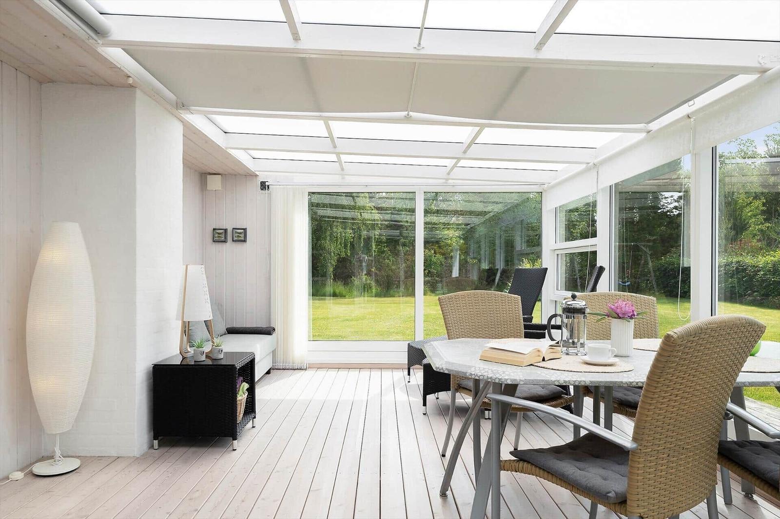 Glasdach über Essbereich und Sitzbereich mit Blick auf Garten.