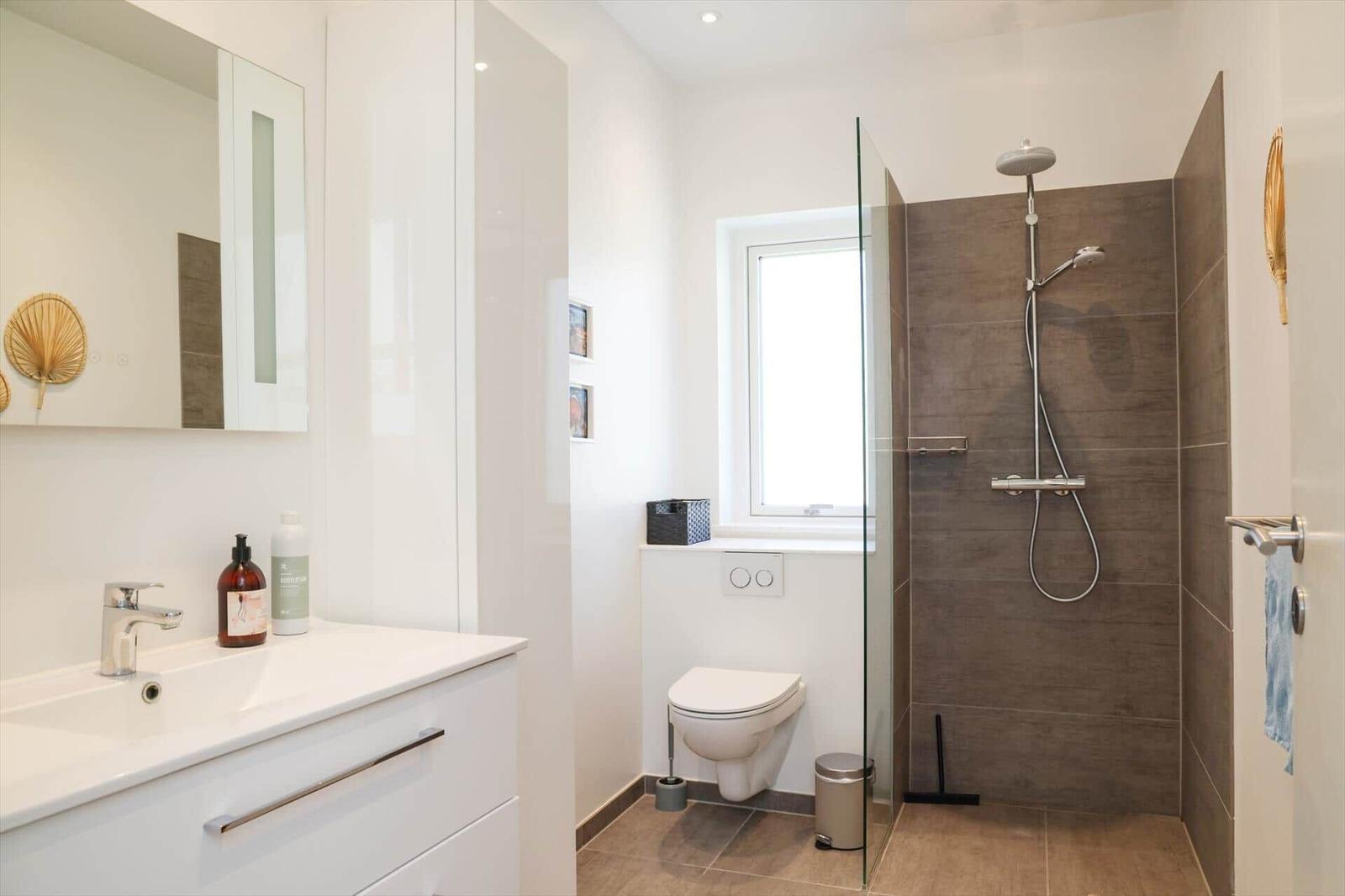 Bathroom with shower, toilet, and sink with mirror