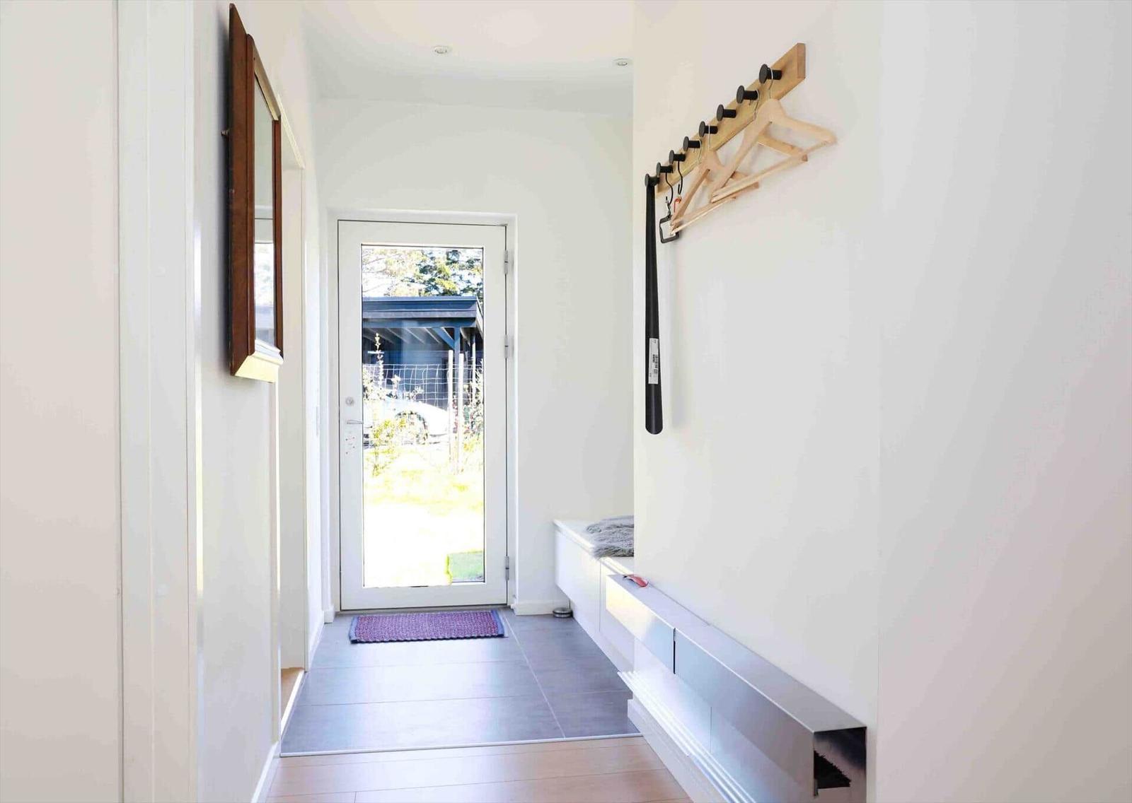 Entrance area with wooden rack, flooring, and door to the outside.
