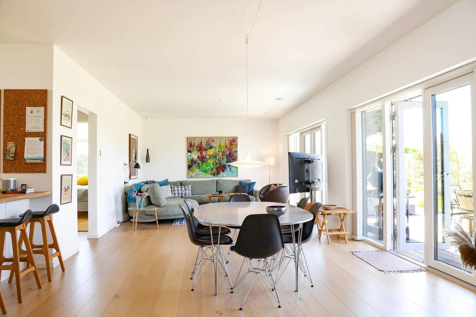 Living and dining area with dining table, sofa, and glass doors to the terrace.