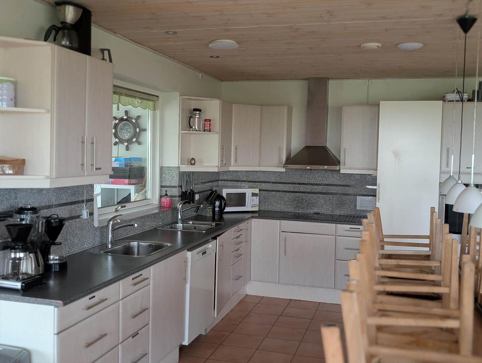 Kitchen with light cabinets, worktop, and kitchen appliances.