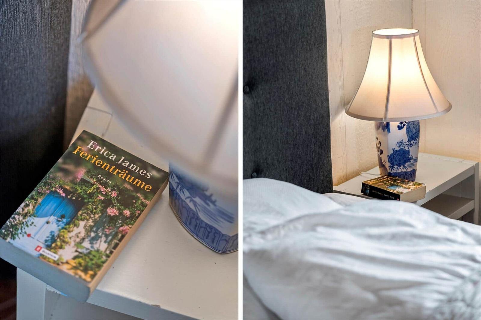 Schlafzimmer mit Nachttisch, Lampe und Buch auf dem Tisch.
