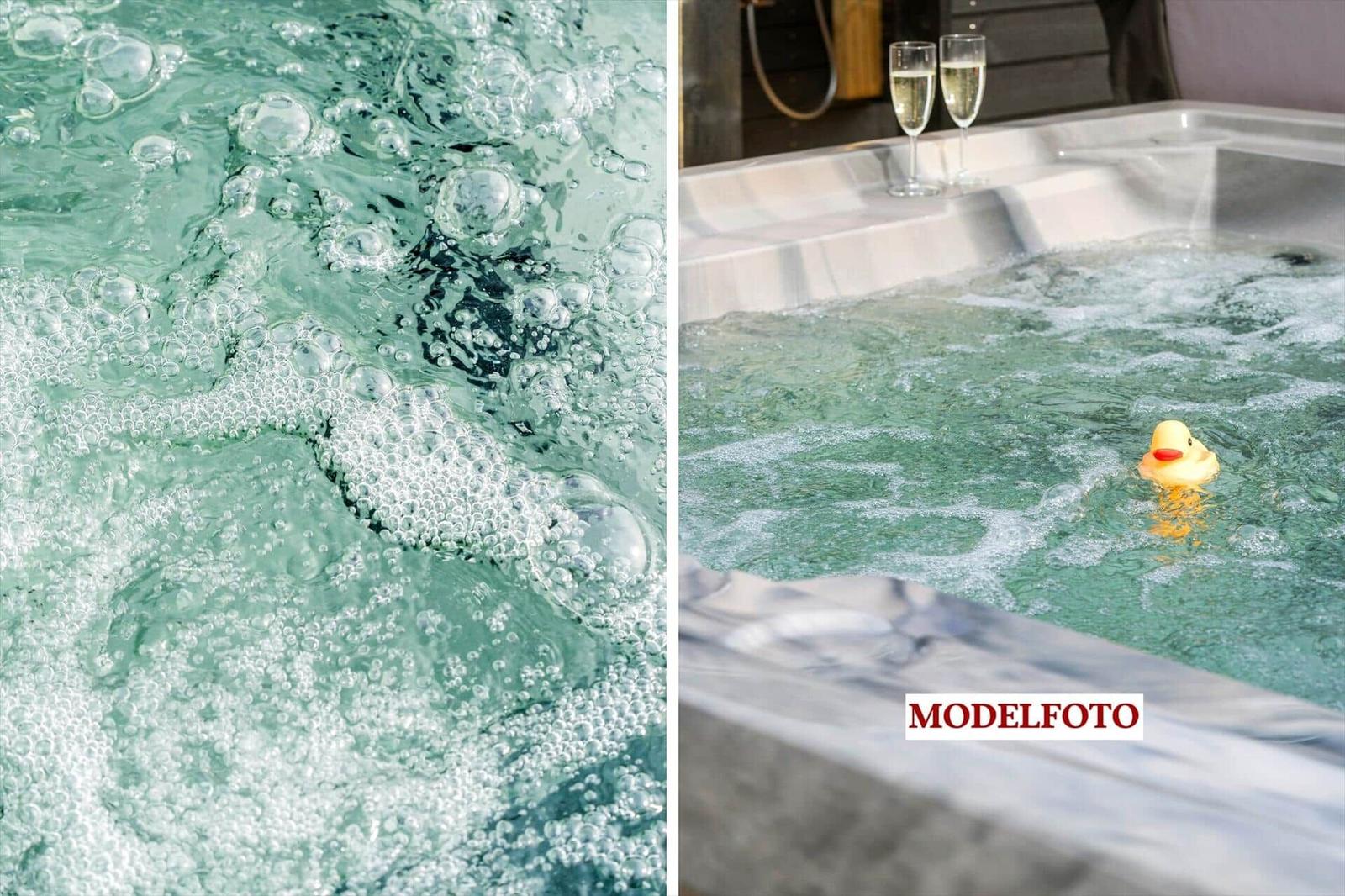Ein Whirlpool mit Schaum und einem gelben Schwimmkäfer. Zwei Gläser Champagner stehen am Rand.