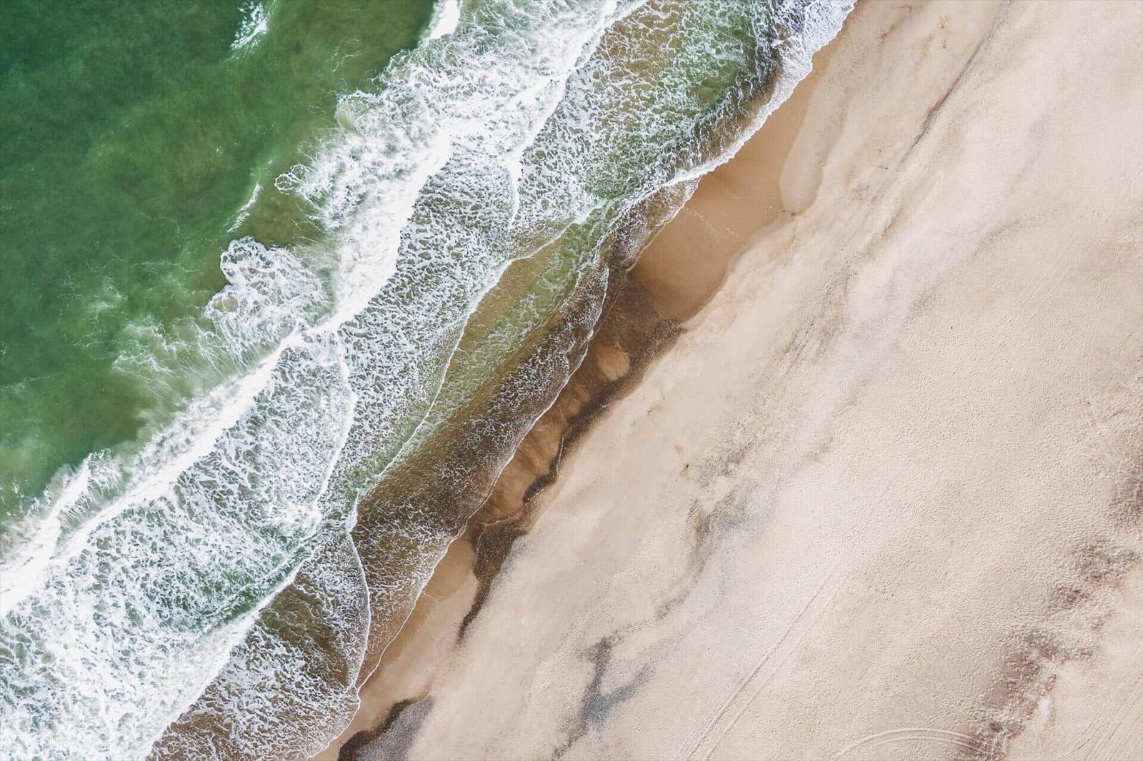 Aerielansicht von Strand und Meer mit Wellen