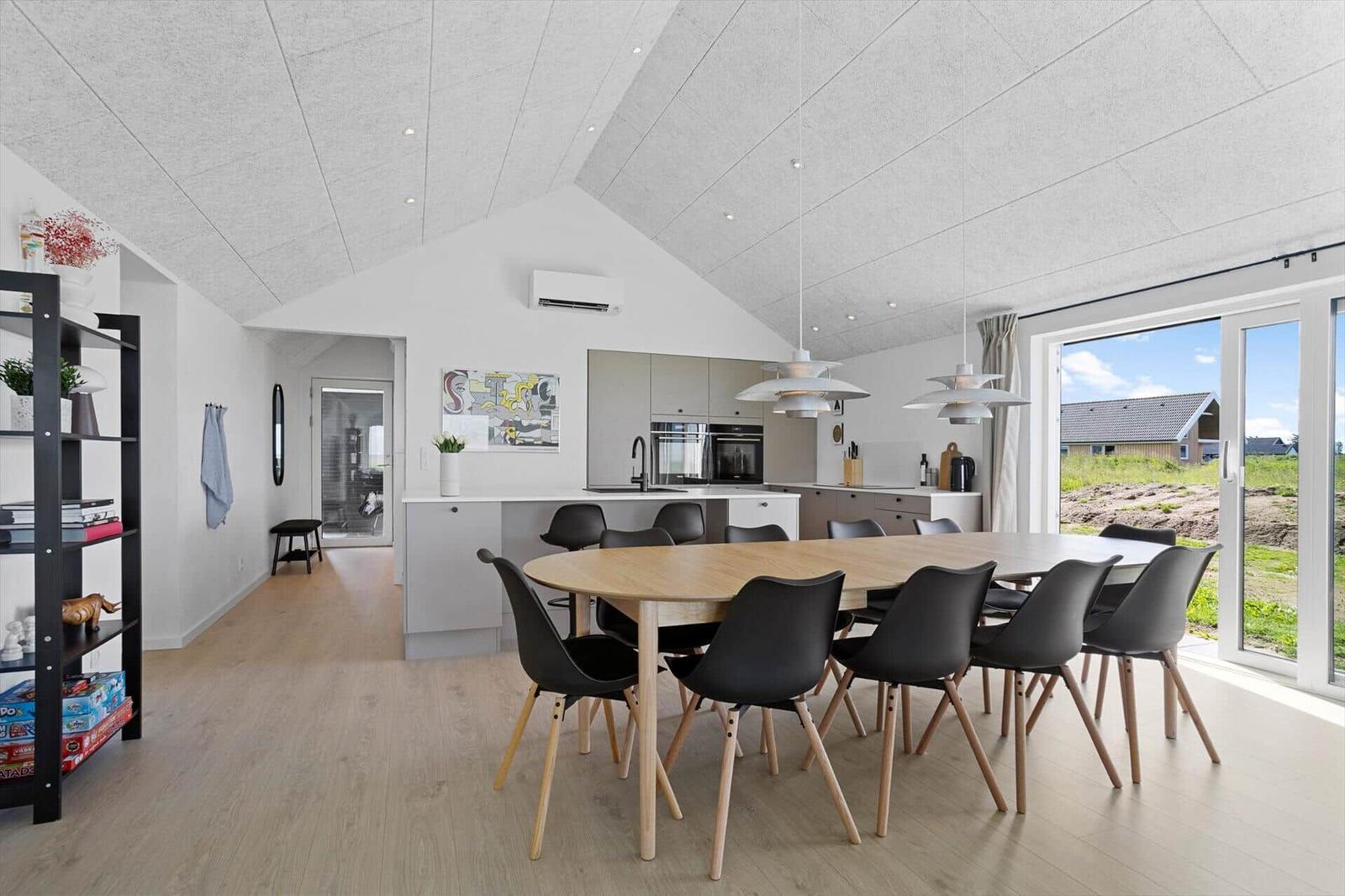 Modern kitchen with dining area and large window view of the landscape.