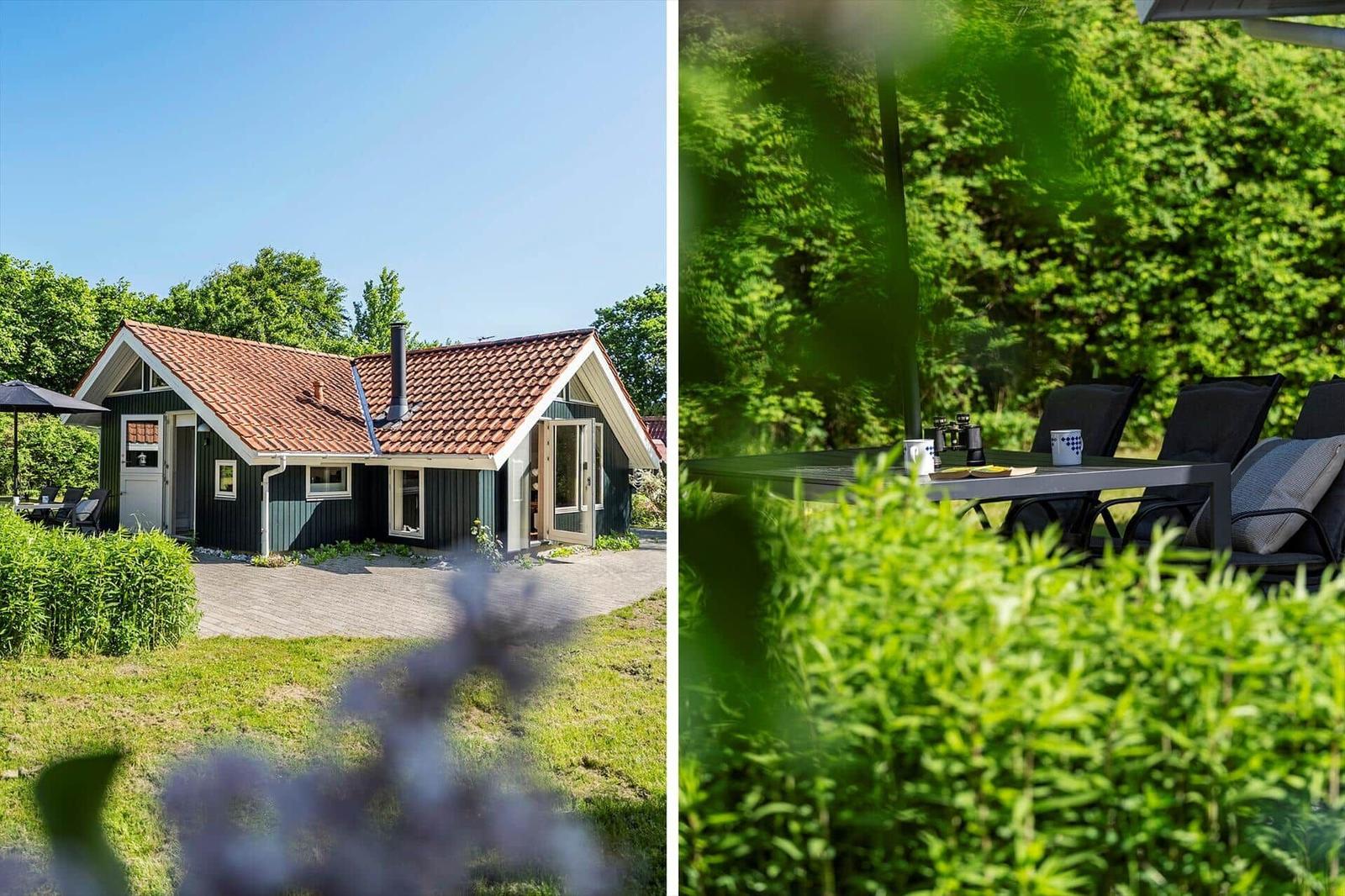 House with terrace and garden. Outdoor table with chairs and view into the green surroundings.