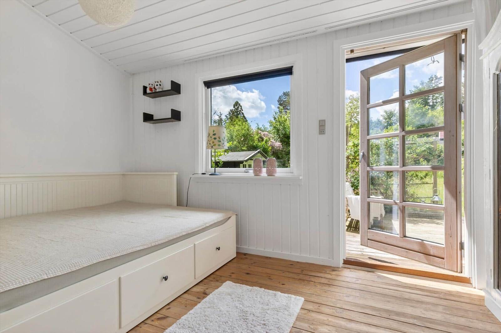 Bedroom with bed, window, and door to terrace.