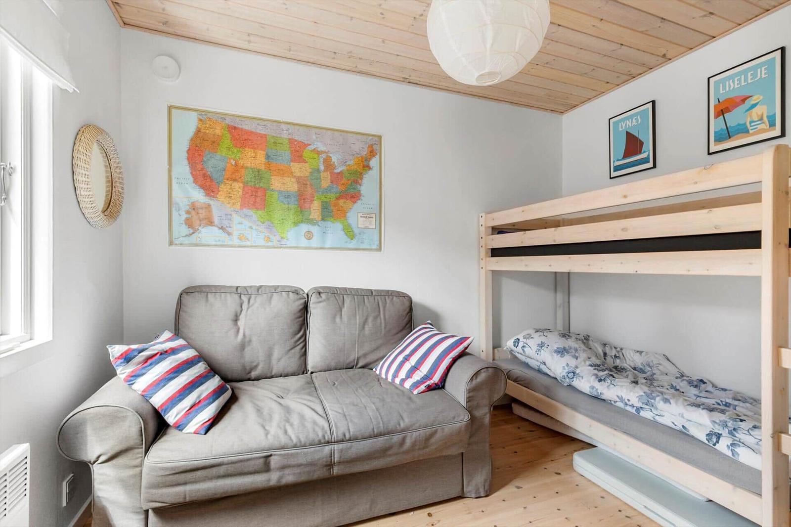 Room with sofa bed, bunk bed, and US map on the wall.