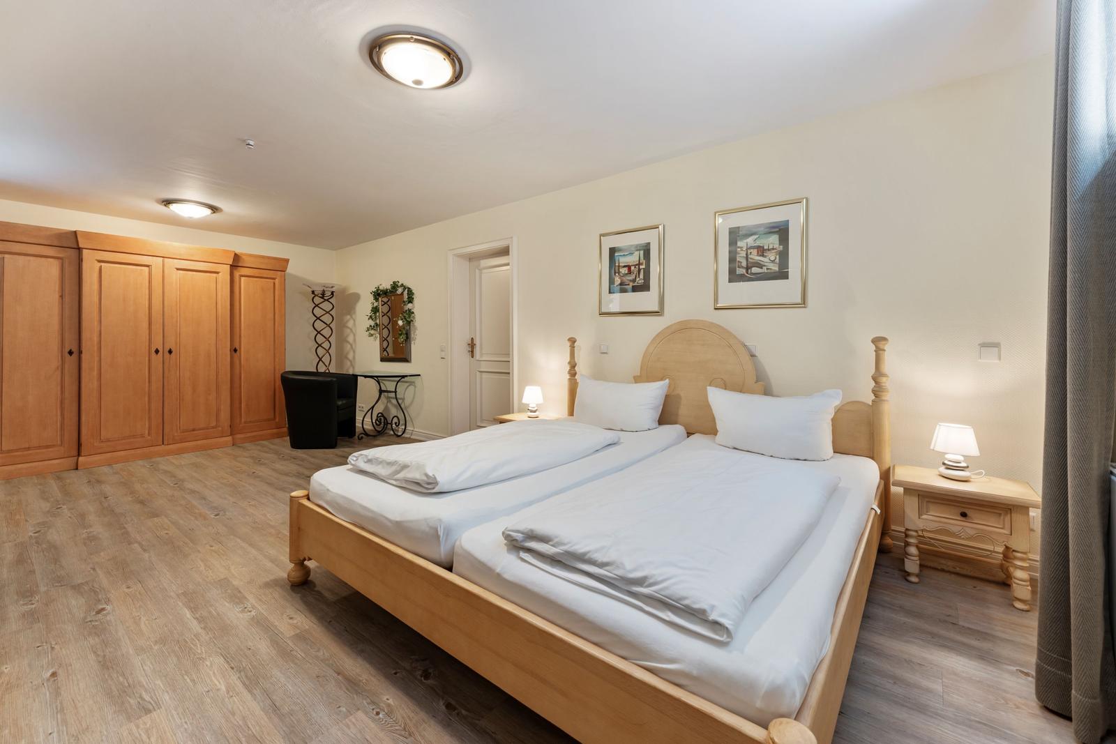 Schlafzimmer mit Doppelbett, Holzmöbel und Kleiderschränken.