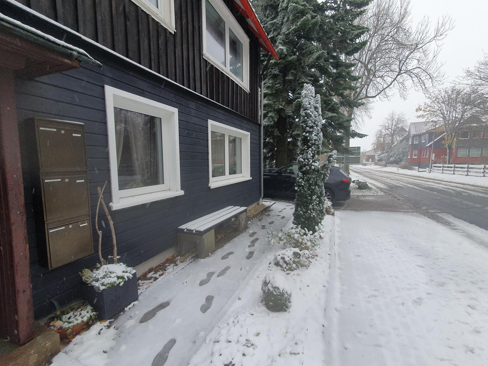 Schneebedeckter Eingangsbereich eines Hauses mit Bank und Briefkasten.