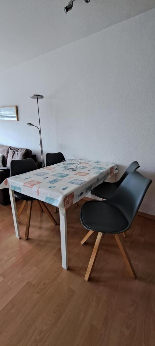Esstisch mit vier Stühlen und Tischdecke auf Holzboden