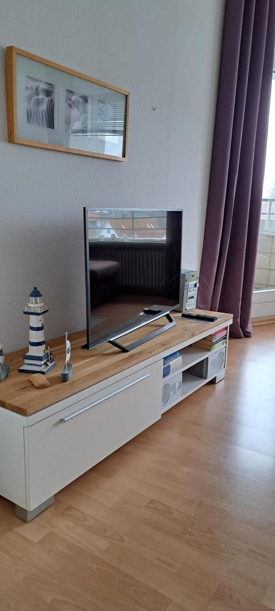 TV auf Holzboard mit Lautsprechern und Dekorationsgegenständen