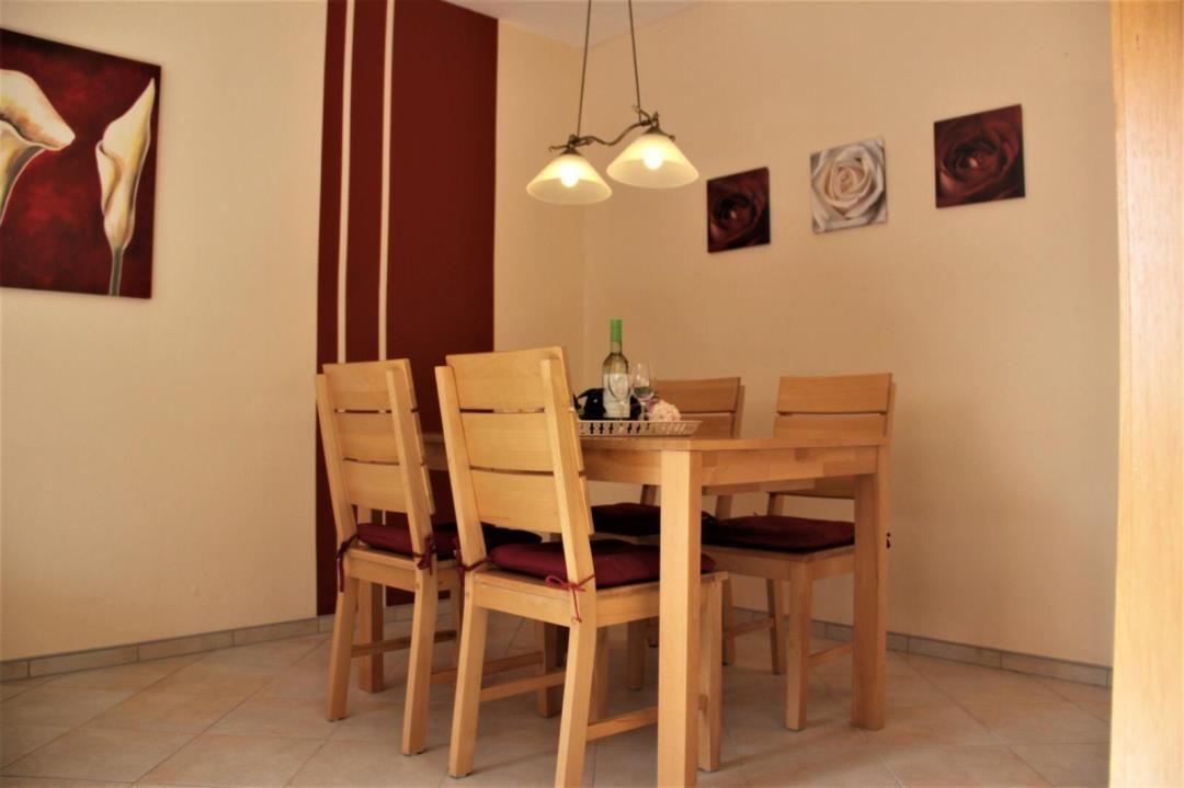Dining room with wooden table, four chairs, and wall art