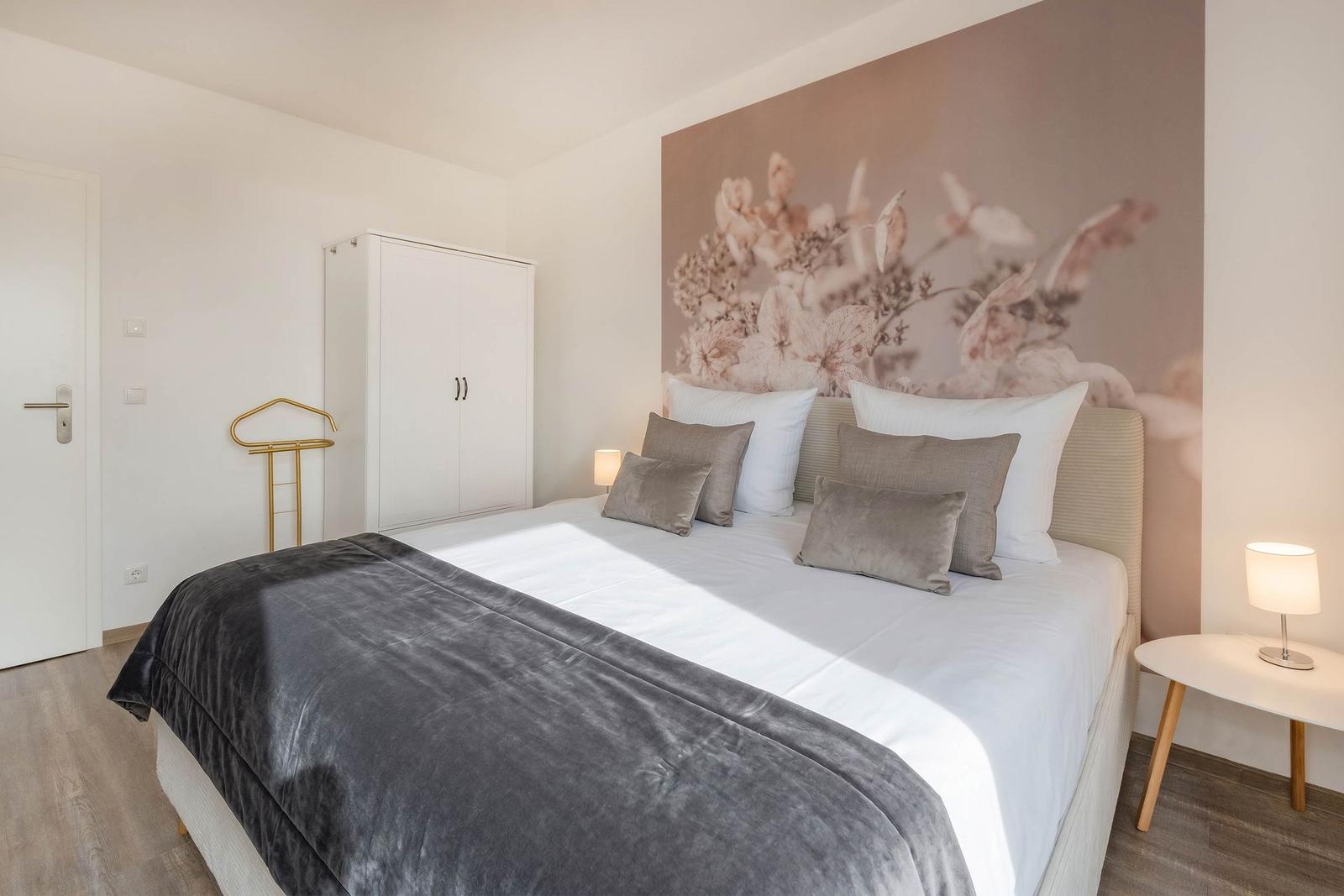Schlafzimmer mit Bett, Wandbild und Nachttisch