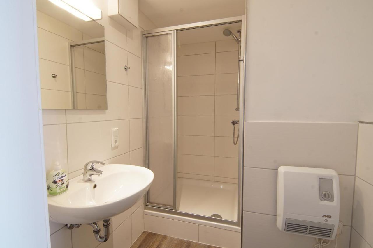 Badezimmer mit Dusche, Waschbecken und Handtuch warmer
