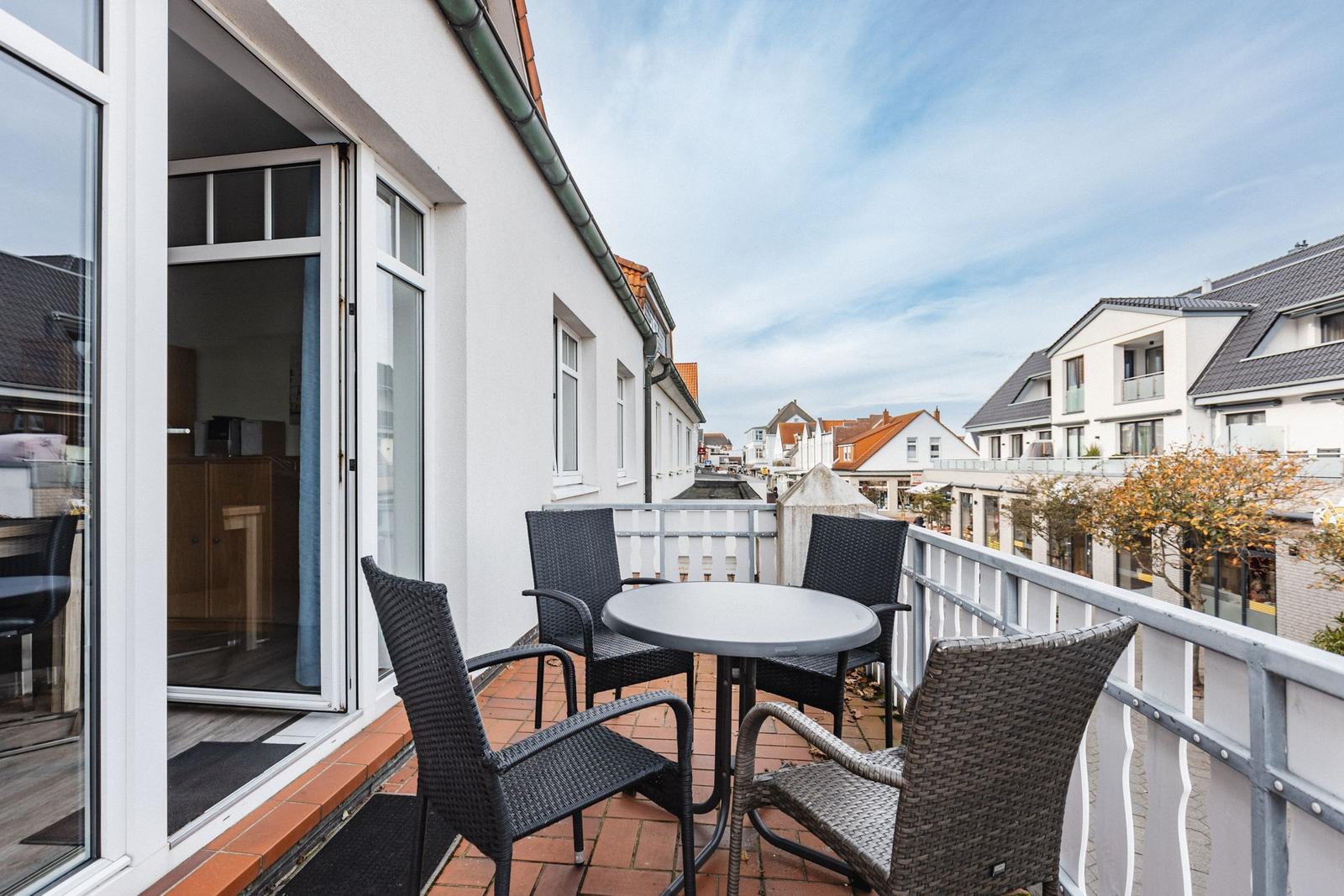 Terrasse mit Tisch und Stühlen, Blick auf Straße und Häuser