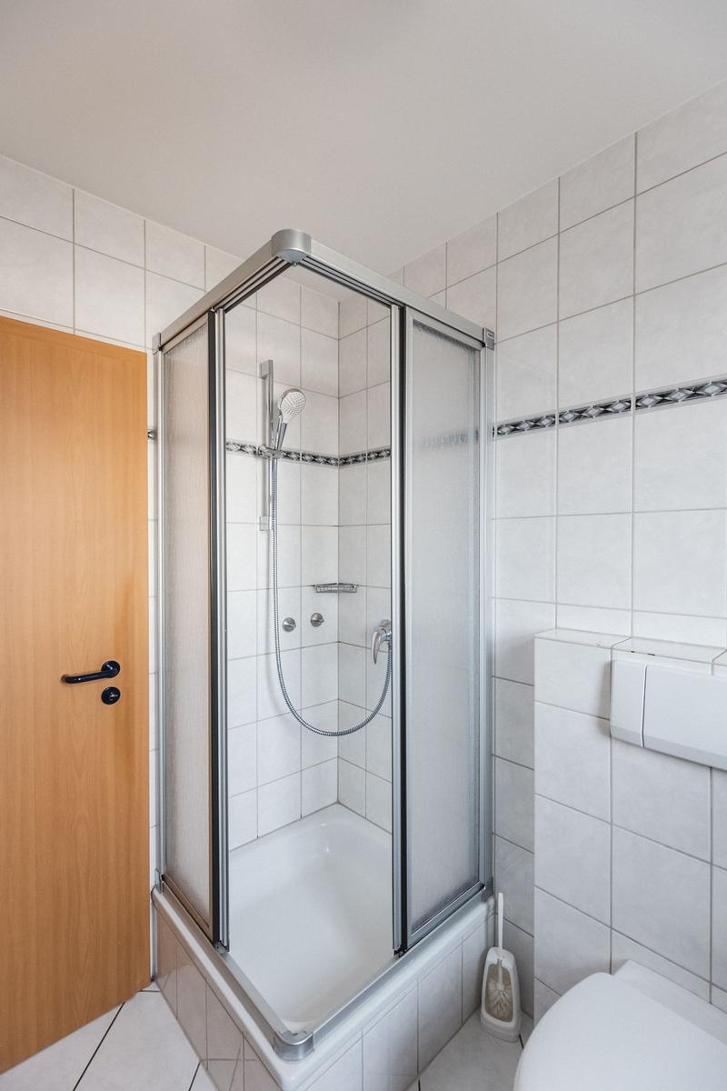 Bad mit Dusche, Toilette und Holztür