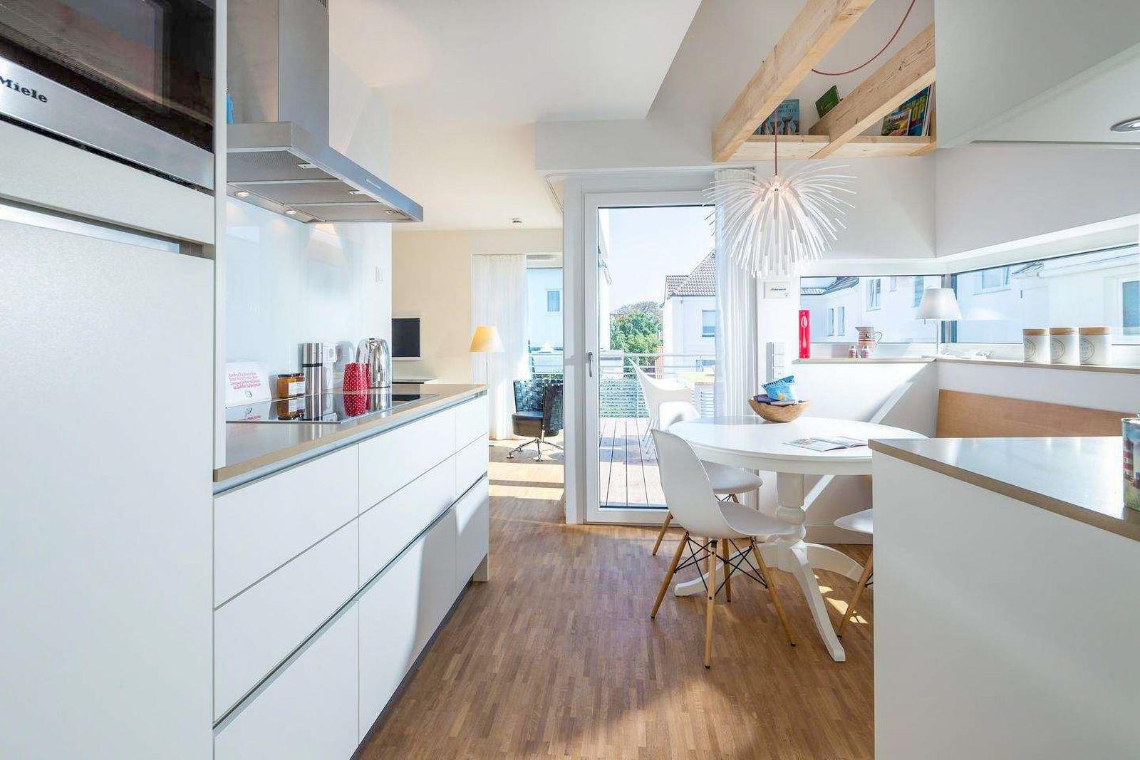Küche mit Esstisch, Terrasse und Balkon. Moderne Einrichtung mit Holzboden.
