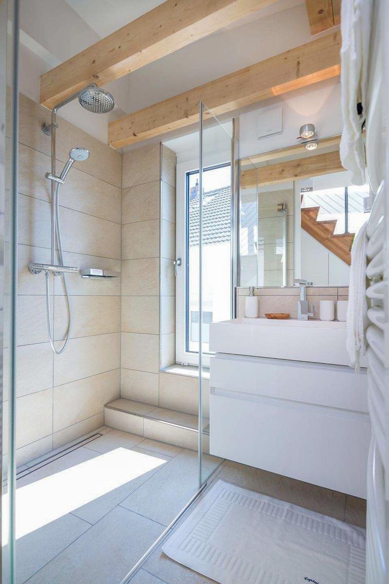 Dusche mit Glaswand, Waschbecken und Fenster