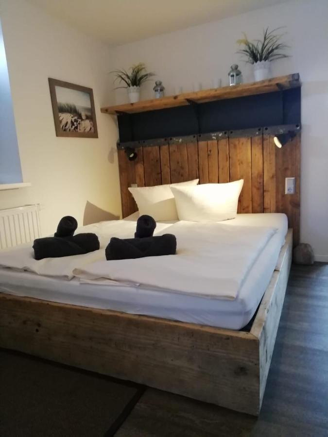 Doppelbett mit Holzgestell, Kopfteil mit Pflanzen und Wandbild.