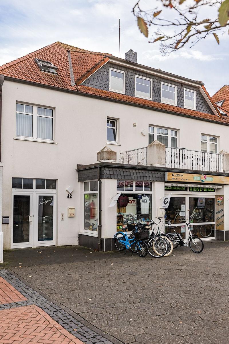 Haus mit Laden und Fahrrädern vorne. Dach mit Schiefer und Dachfenstern.