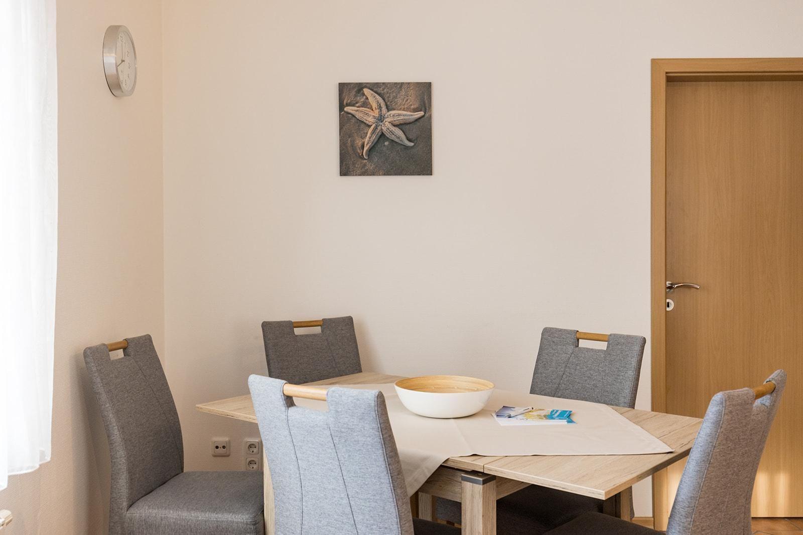 Dining room with table, chairs, and wall art featuring a starfish