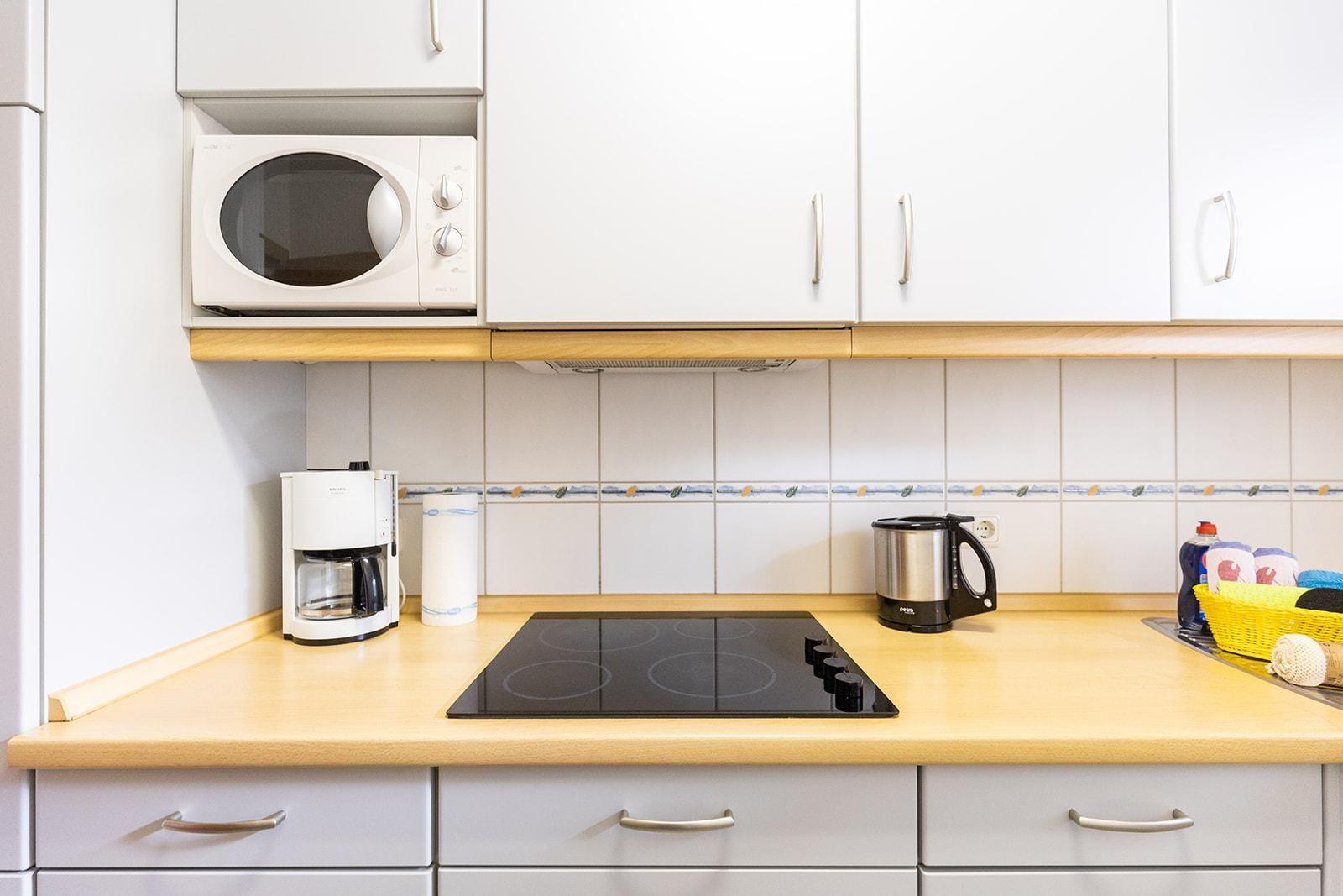 Kitchen with worktop, stove, coffee maker, and microwave.