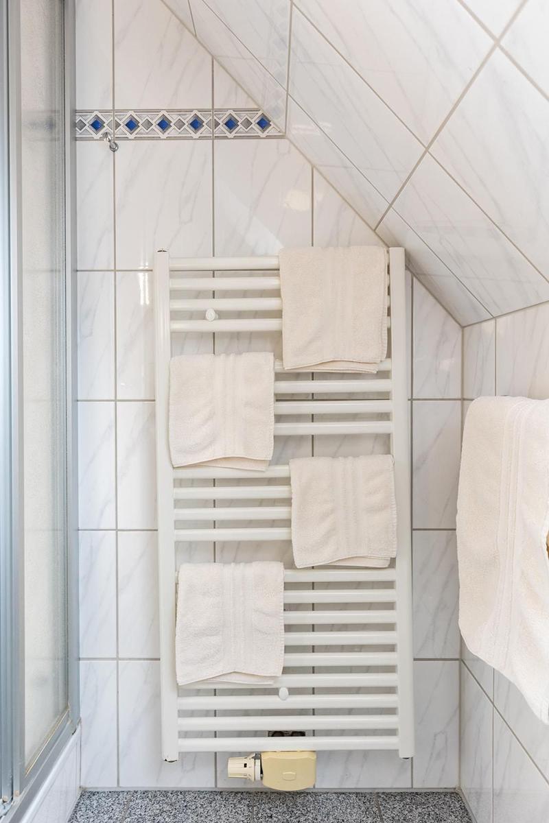 Badezimmer mit Heizkörper und weißen Handtüchern an der Wand.