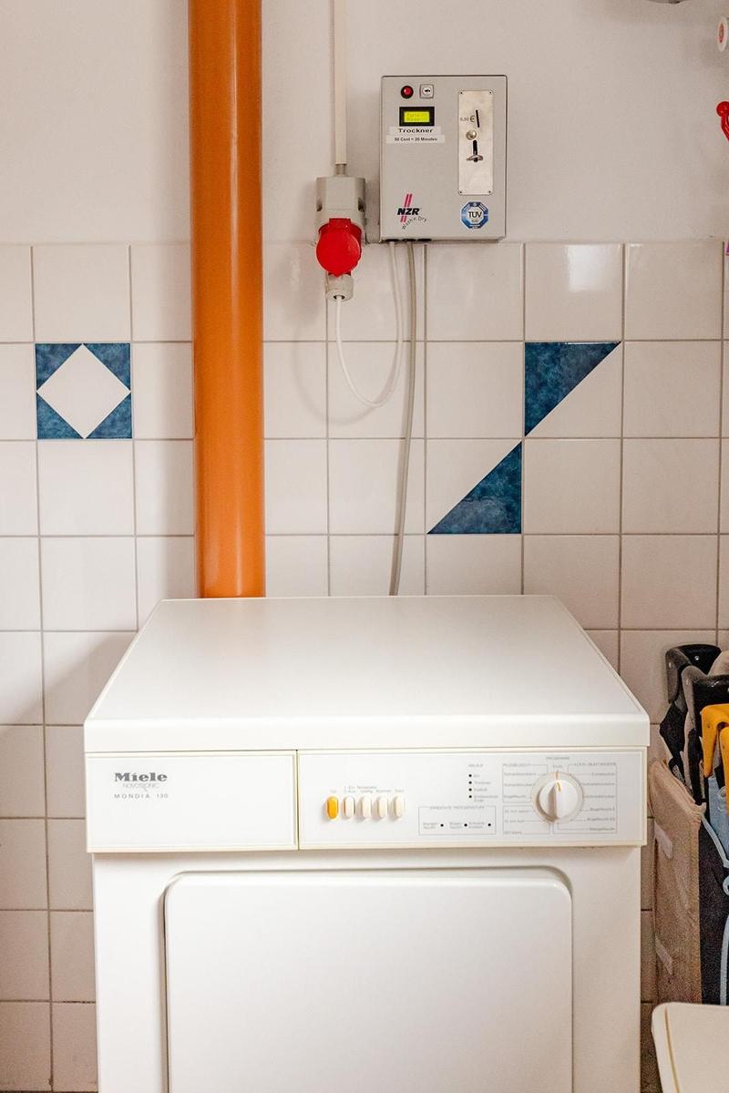 Waschmaschine mit Trockneranlage an Wand mit Fliesen