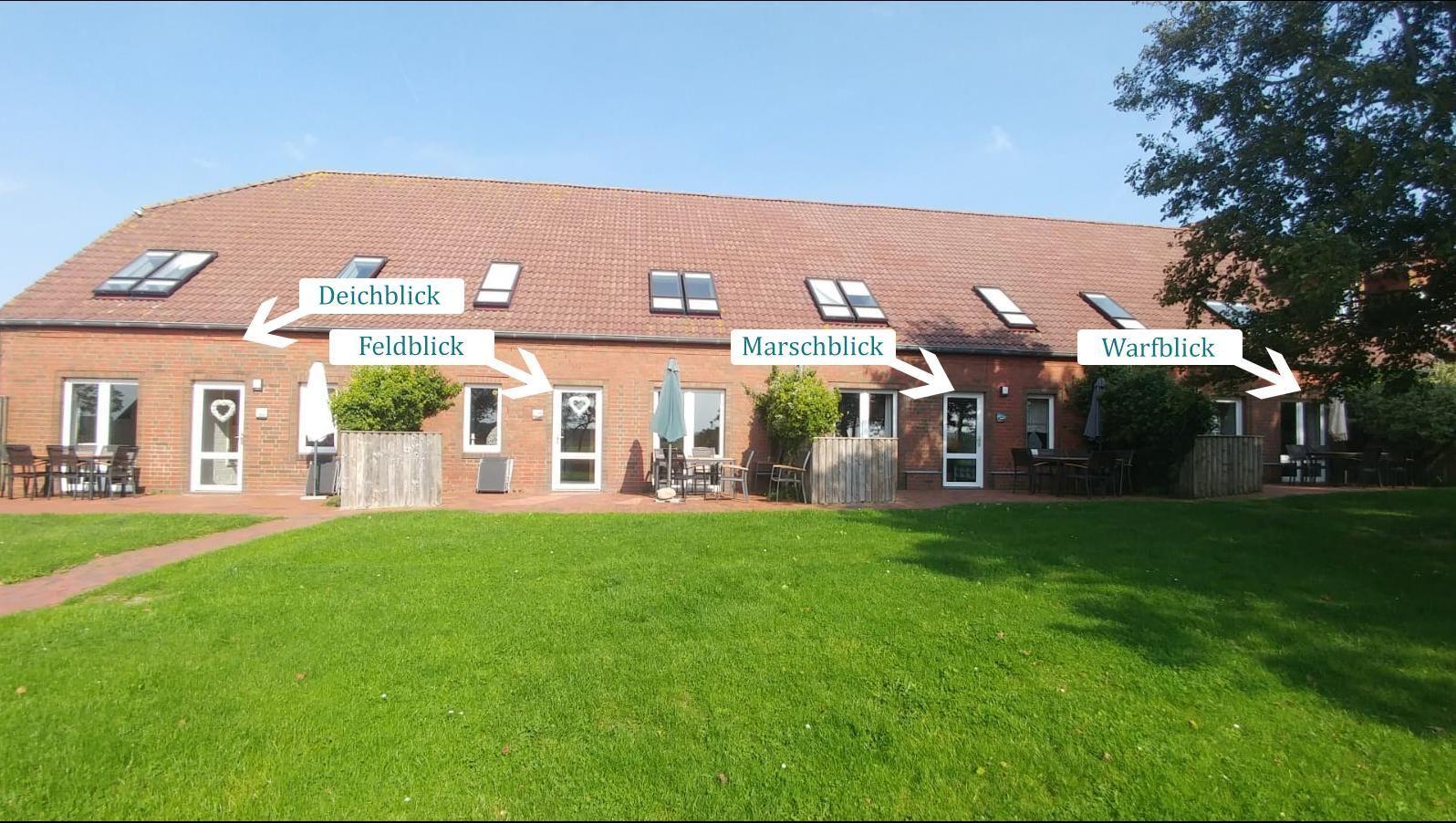 Holiday home with views of dike, field, marsh, and warf. Outdoor area with tables and chairs.