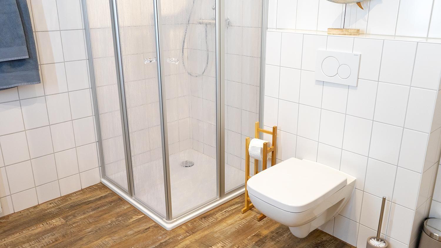 Bad mit Dusche, Toilette und Holzboden