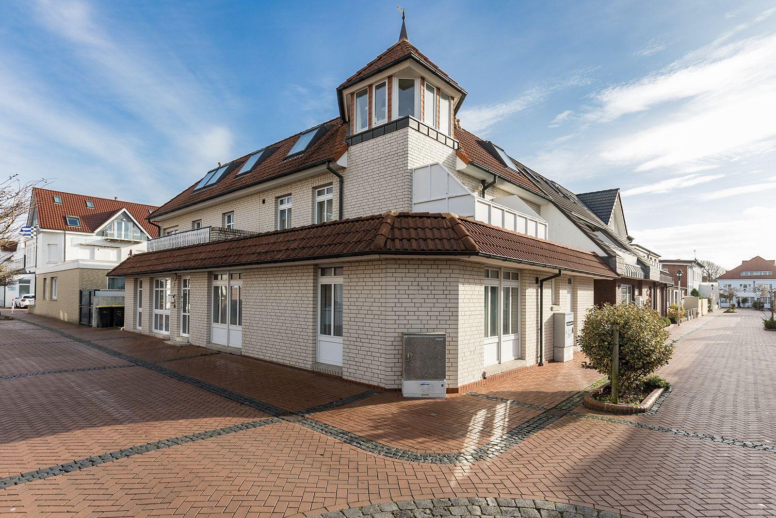 Ein zweistöckiges Haus mit Ziegeldach und weißem Klinkerfassade.