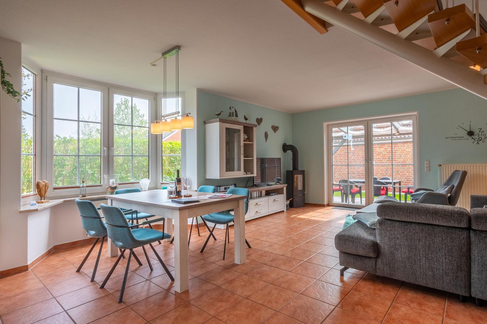 Wohn- und Essbereich mit Holztreppe, Essplatz und Blick auf Garten
