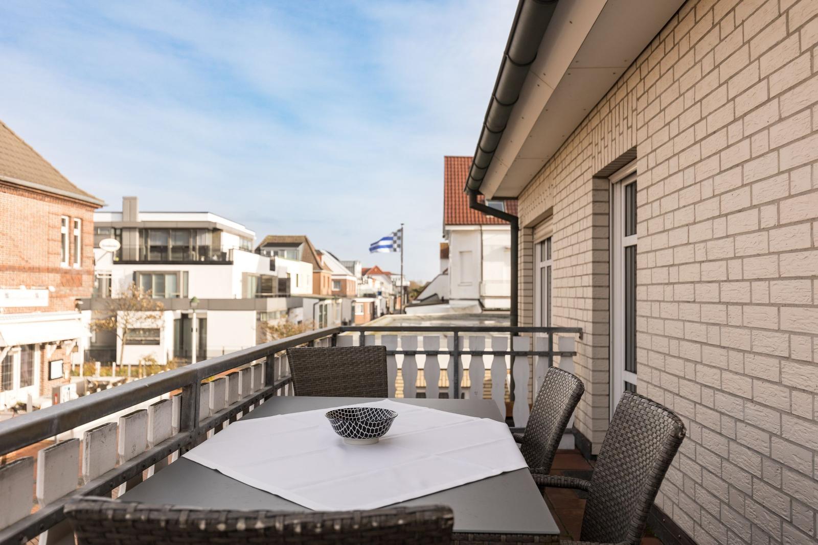 Terrasse mit Tisch, Stühlen und Blick auf die Straße.