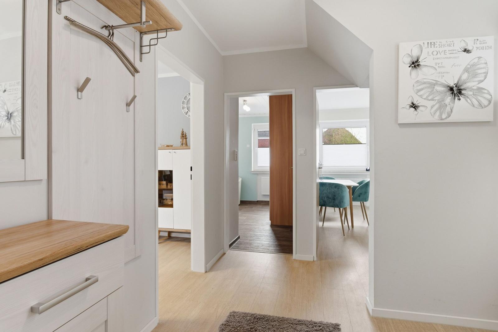 Eingangsbereich mit Garderobe, Flur und Blick in Esszimmer und Schlafzimmer.