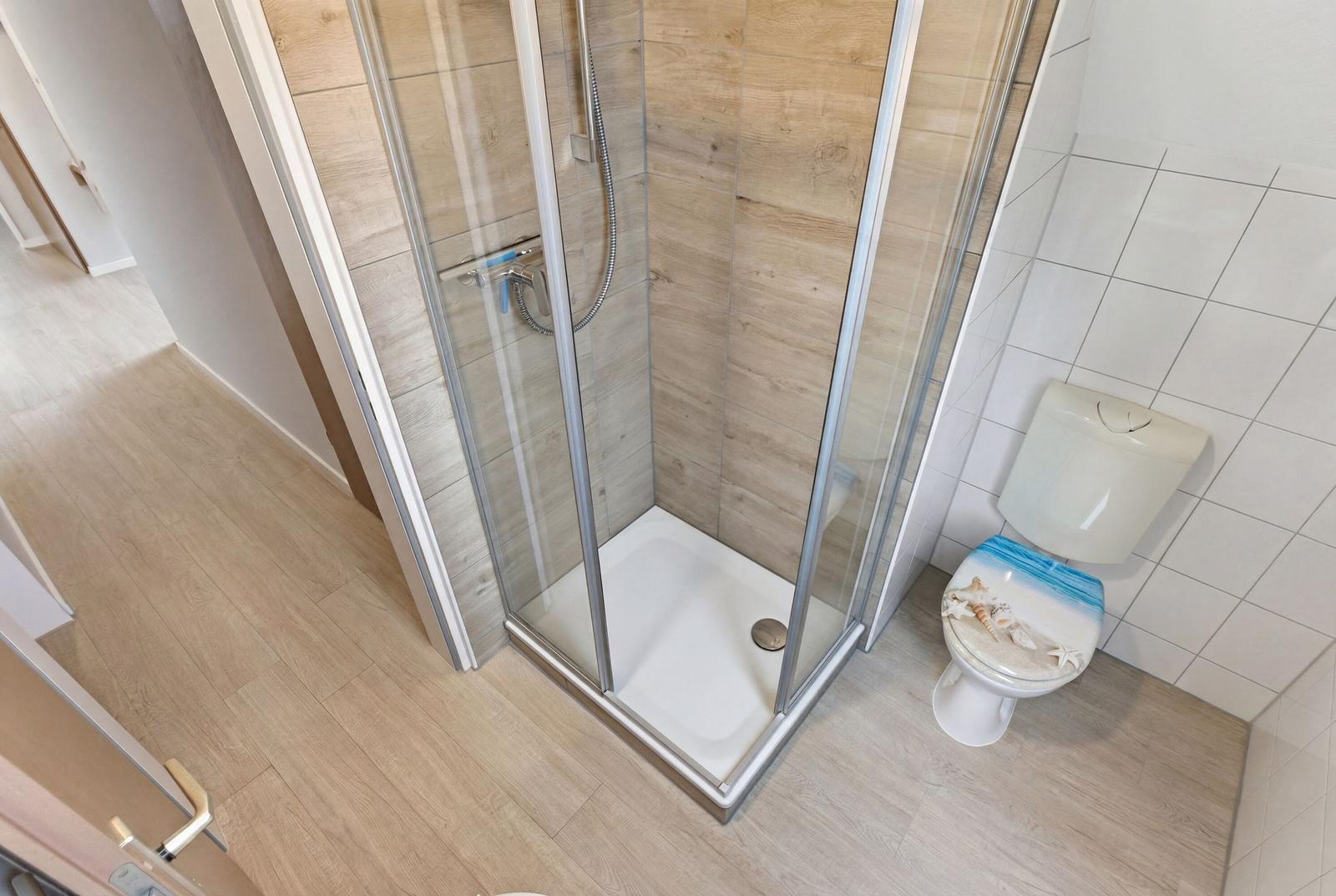 Duschbad mit Dusche und Toilette mit Meeresmotiv